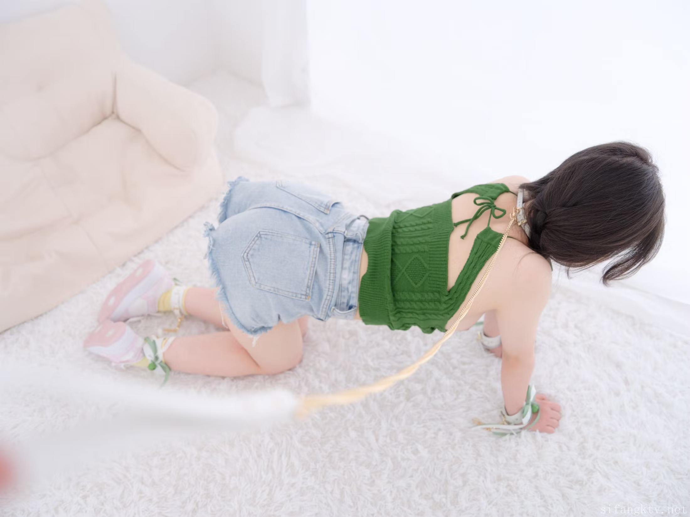 紧急企划模特奶昔身穿绿色吊带与牛仔短裤坐在沙发上